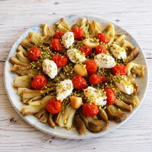 Ensalada templada de berenjenas asadas, tomates cherry, queso ricotta y pistachos